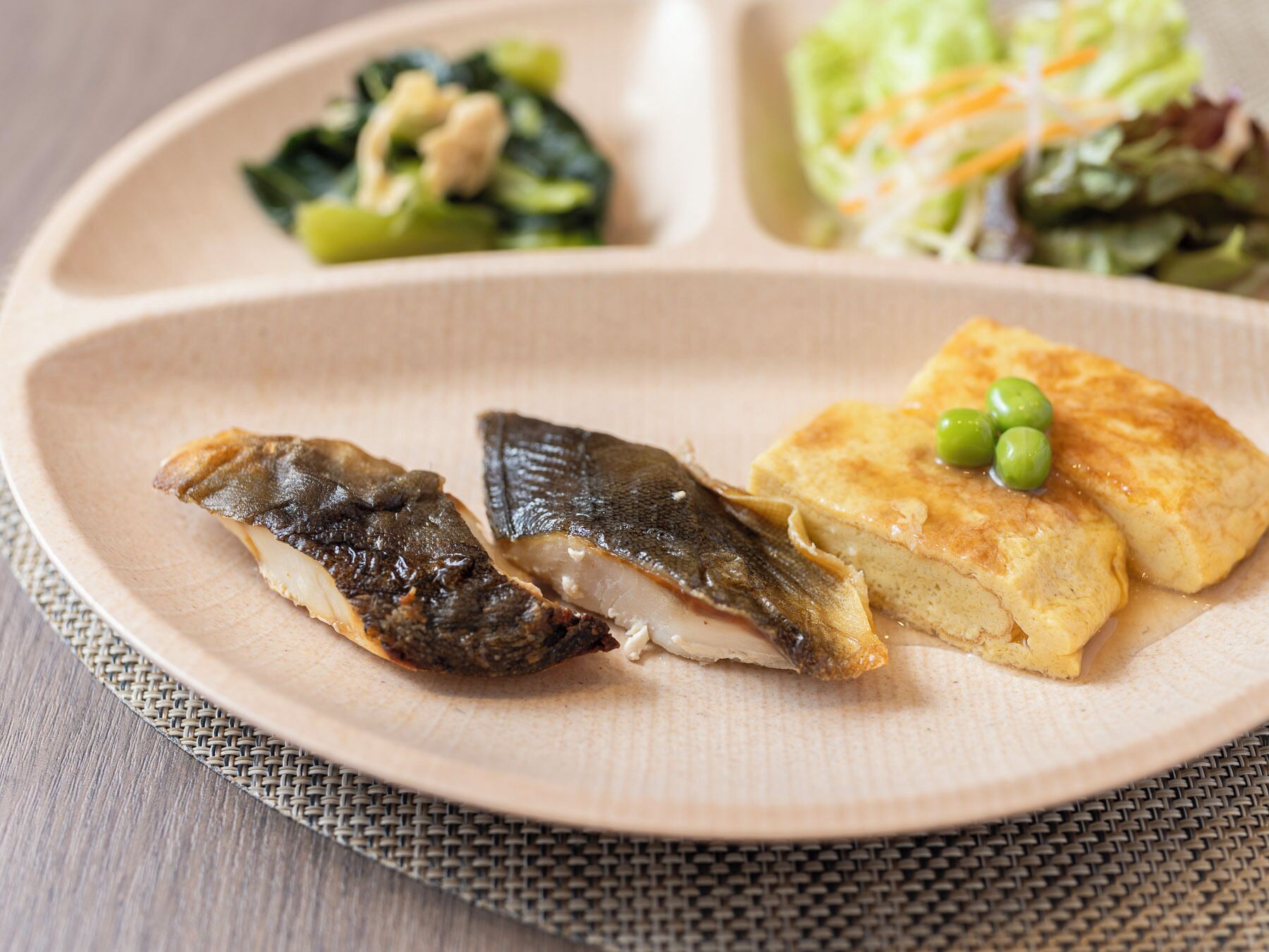 Un plato con pescado, tofu y verduras.
