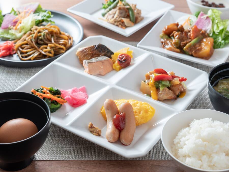 A variety of dishes on a table, including noodles, fish, and vegetables.