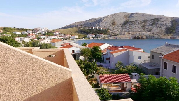 A coastal town with buildings and a mountain in the background. - Cosy Apartment With sea View and one Bedroom (Novalja)