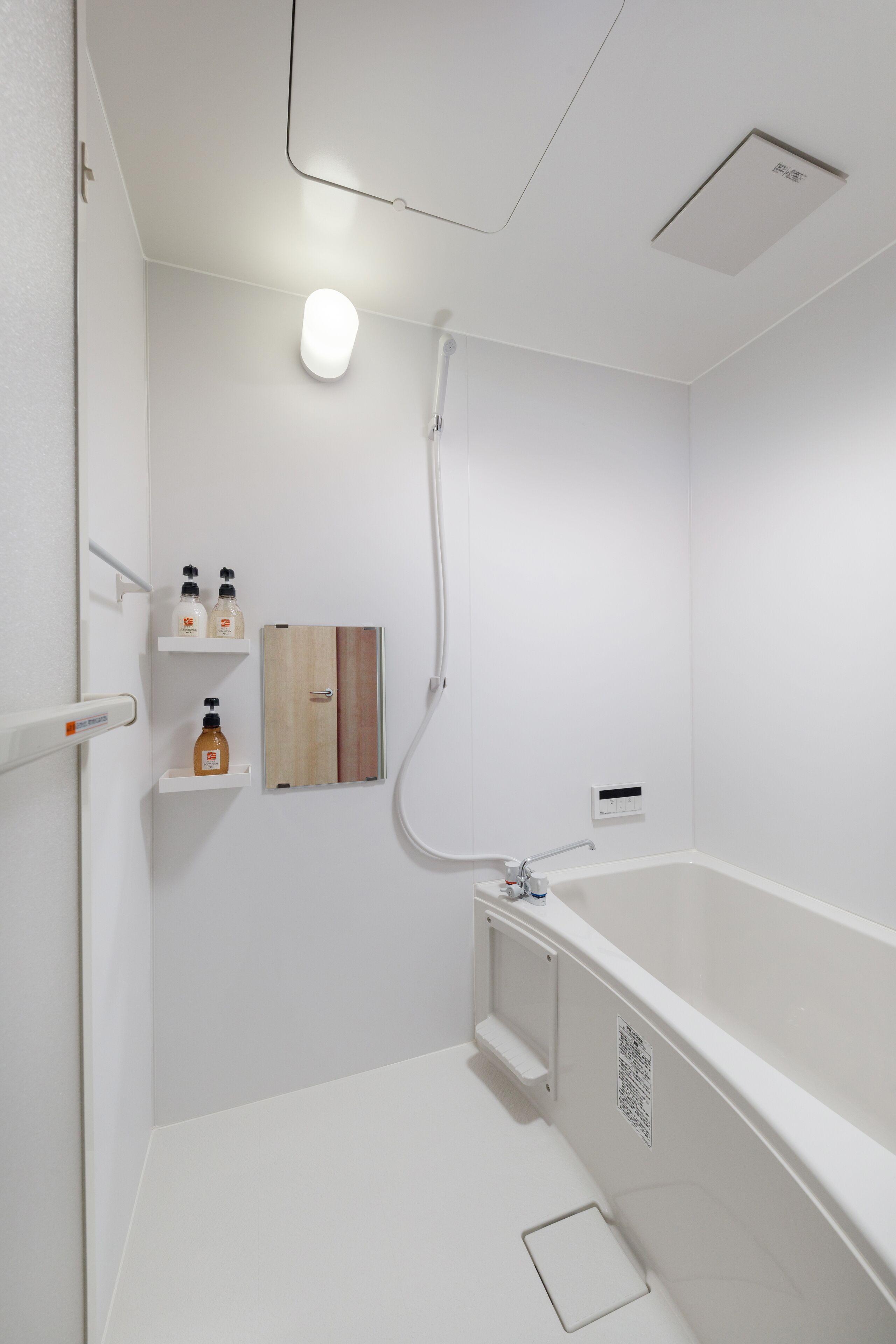 A modern bathroom with a white bathtub, a shower, and a wooden medicine cabinet.