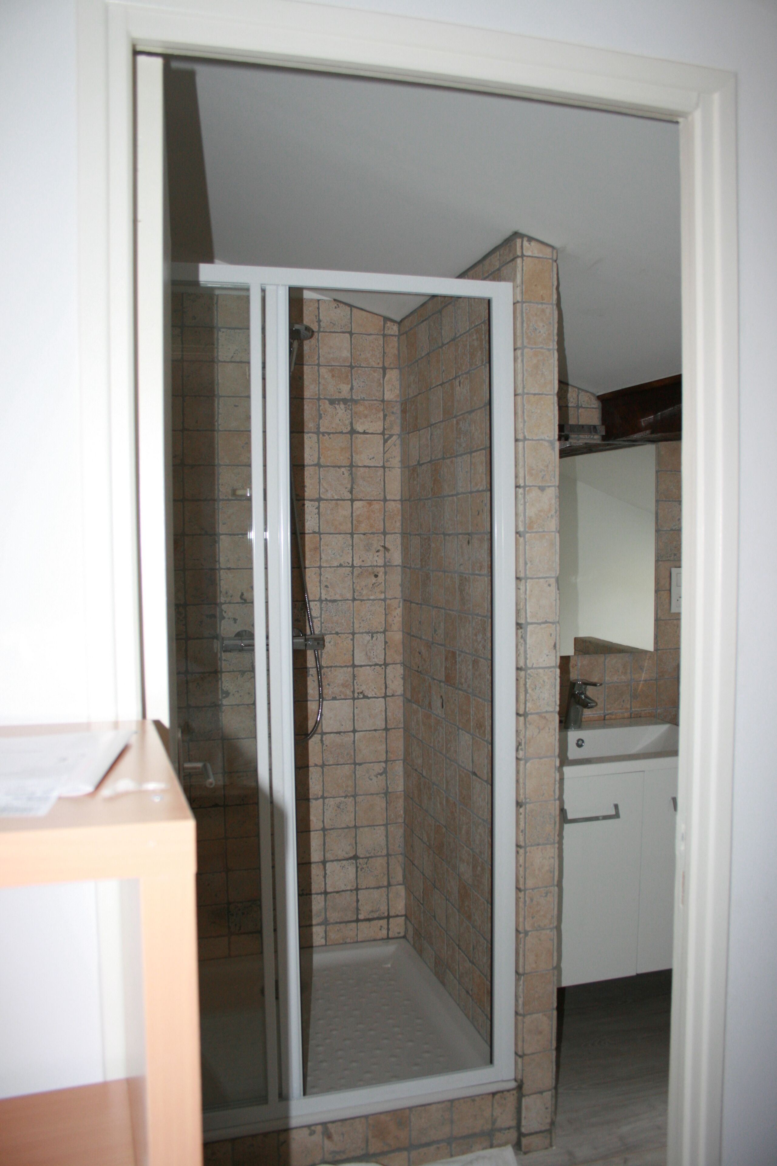 A bathroom with a shower, a sink, and a mirror.