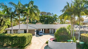 A two-story building with a tiled roof, a garage, and a parking area. - Byron at Clarkes - location perfection! Walk everywhere (Byron Bay)