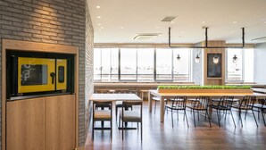 Un restaurant moderne avec un mur en briques, des meubles en bois et de grandes fenêtres.