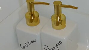 Two white bottles with gold pumps, labeled "Conditioner" and "Shampoo". - Guest house Shijo K12 (Kyoto)