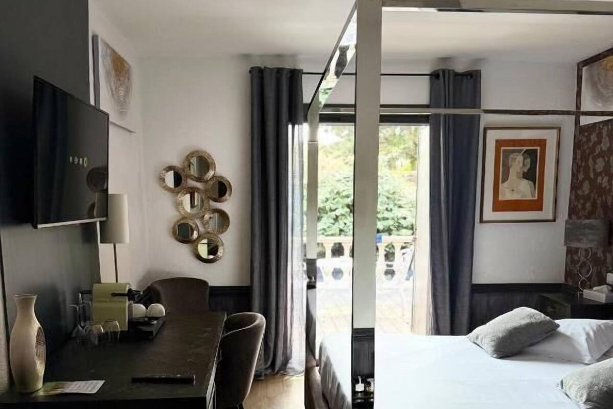Une chambre d’hôtel équipée d’un lit, d’un bureau, d’une télévision et offrant une vue sur l’extérieur.