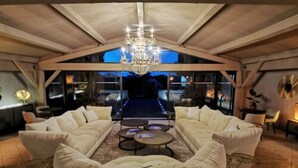 A spacious living area with a high ceiling and a chandelier, featuring a sofa set and a coffee table. - La Villa Dune, Hôtel & Spa  (Gassin)