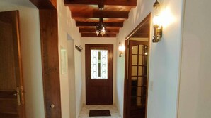 A hallway with a wooden door, a tiled floor, and a window with decorative glass. - Charming 7-bedroom house in Cauterets (Cauterets)