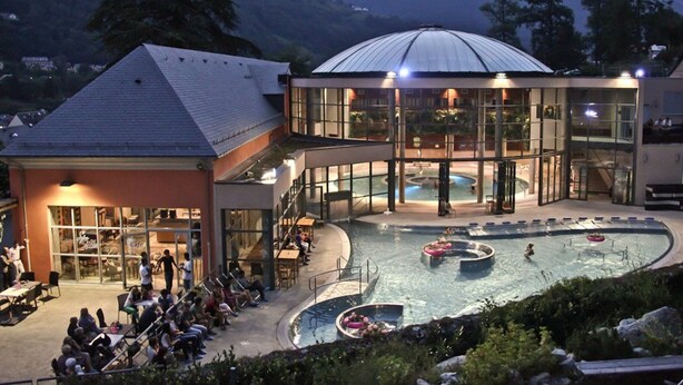 A hotel with a pool area, outdoor seating, and a mountain backdrop. - Charming 7-bedroom house in Cauterets (Cauterets)