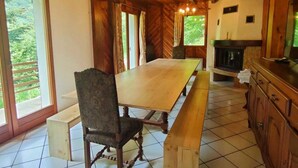 A wooden interior with a large dining table, chairs, a chandelier, and a fireplace. - Charming 7-bedroom house in Cauterets (Cauterets)