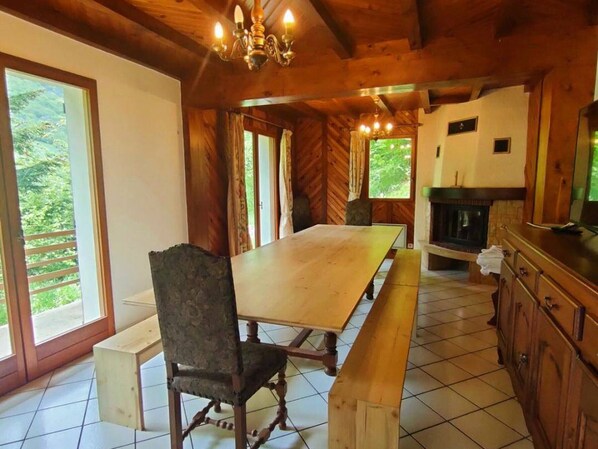 A wooden interior with a large dining table, chairs, a chandelier, and a fireplace. - Charming 7-bedroom house in Cauterets (Cauterets)