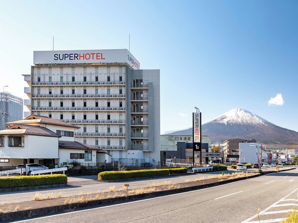 Edificio de un Super Hotel con varios pisos y una vista de una montaña al fondo.