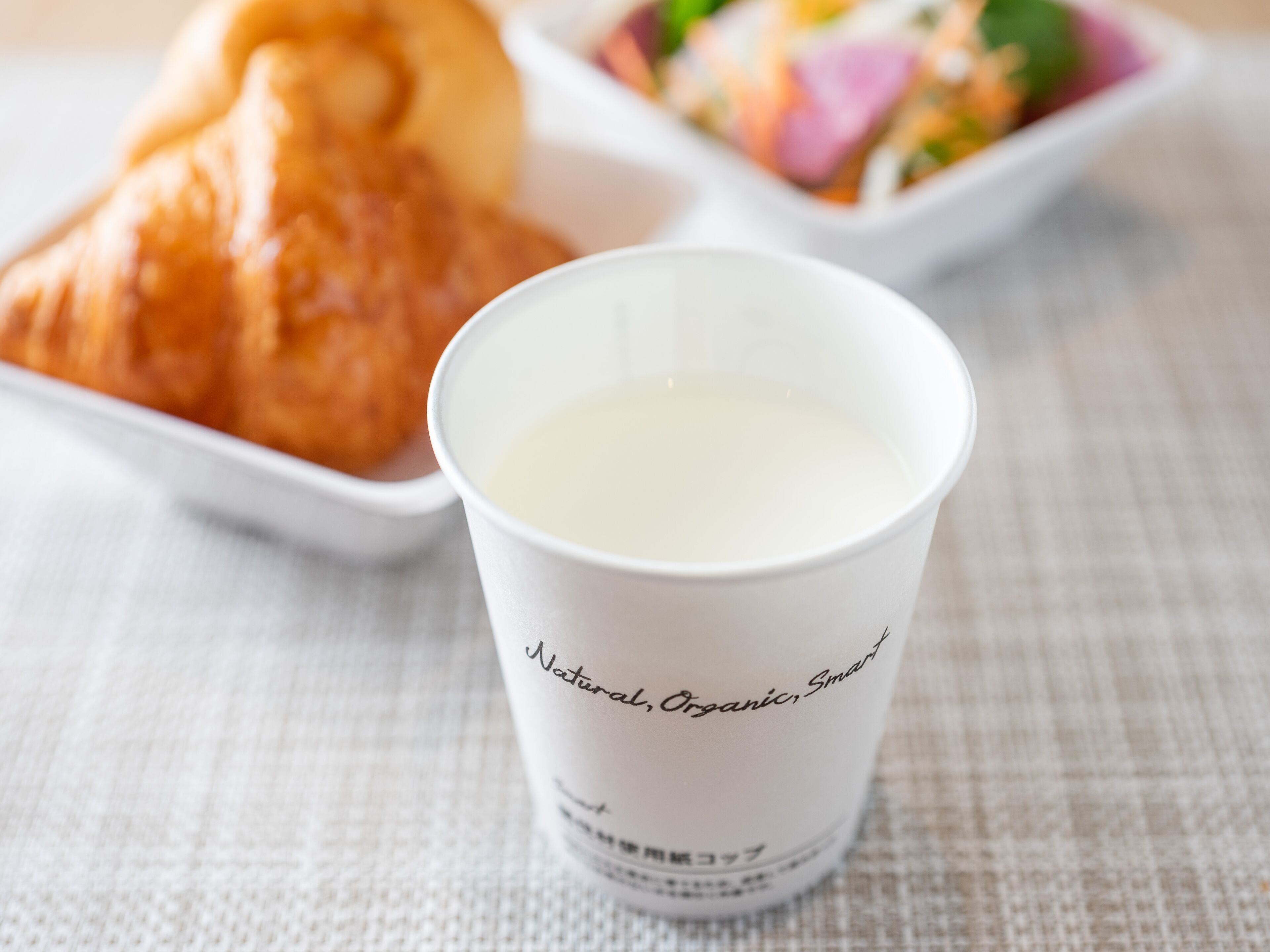 A cup of milk with a label that reads "Natural, Organic, Smart".