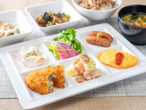 Un plato rectangular blanco con diversos alimentos, incluyendo una milanesa, ensalada y otros platos.