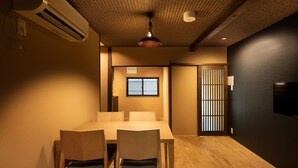Una habitación con una mesa de comedor y sillas de madera, un ventilador de techo y una puerta corrediza con ventanal.