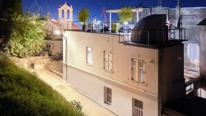 A building with a rooftop terrace, a bell tower in the background, and construction cranes nearby. - Luxury Sea View Apartment Altana (Pula)