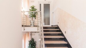 Eine moderne Treppe mit Metallgeländern und Blumentöpfen.