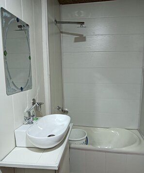 A bathroom with a white sink, a mirror, a shower, and a bathtub. - Golden Crest Houseboats (Srinagar)