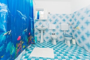 Un baño con suelo a cuadros, un lavabo, un bidé y un inodoro.