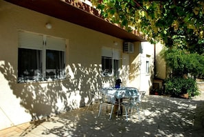 Relax under the pergola, surrounded by lush foliage and comfortable seating.