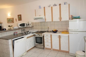 Kitchen features a central island, sink, stove, oven, microwave, and refrigerator.
