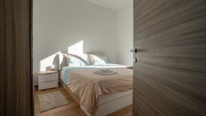 A bedroom with a bed, bedside tables, and a nightstand. - Nature View House With Sauna (Tolmin)