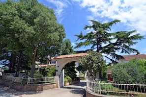 Escape to a serene oasis surrounded by lush greenery and a traditional stone archway.