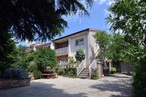 Stunning two-story residence with a balcony and lush green surroundings.