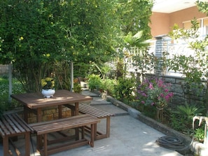 Relax in a serene outdoor space surrounded by lush greenery and a stone wall.