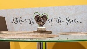 Keukendecoratie met een hartvormig object op een stapel boeken, en een muur met de tekst 