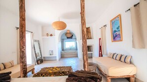 Una stanza con un letto, una panca di legno, un lampadario e un quadro appeso al muro.