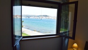 A room with a window overlooking a marina and a bridge.