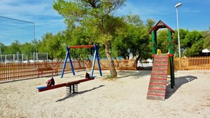 A playground with swings, a seesaw, and a climbing structure.