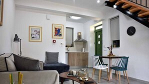 A modern living room with a sofa, a coffee table, and a dining area with chairs and a table.