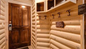 A log cabin interior with a wooden door, a welcome sign, and a sign instructing to remove shoes before entering. - Abode at Black Bear #103, hot tub, pool & gym, Deer Valley (Park City)