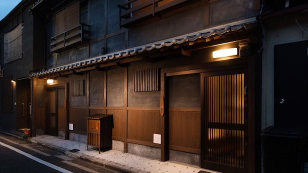 Ein traditionelles japanisches Gebäude mit mehreren Holztüren und einem Ziegeldach.