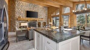 A kitchen with a stone wall, wooden ceiling, and a large island with a marble countertop. - Abode at Black Bear #431, hot tub, pool, free Main Streetreet shuttle (Park City)