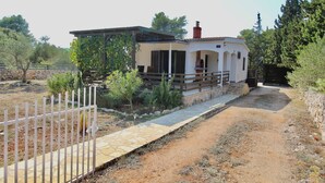 A rustic house with a stone pathway leading to a wooden gate. - Sunny island (Stari Grad)