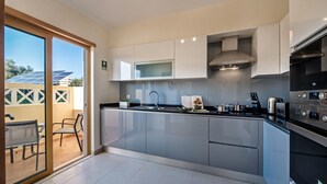A modern kitchen with a large island, built-in microwave, and stainless steel appliances.
