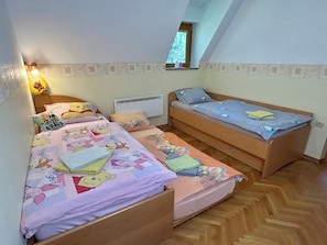Ein Schlafzimmer mit zwei Betten, einem Fenster und einer Heizung.