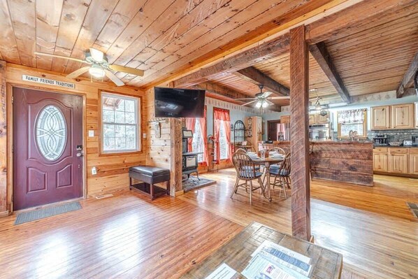 A wooden interior with a dining area, kitchen, and a fireplace. - BLUE CREEK SHOALS | HOT TUB, SAUNA, & GAME ROOM (Cleveland)