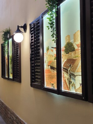 Three windows with shutters, each displaying a different view of buildings. - Hotel Fontana (Novi Sad)