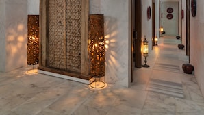 A hallway with a large wooden door, two tall decorative lamps, and a marble floor. - Hillstone Bodrum Hotel & Spa (Bodrum)
