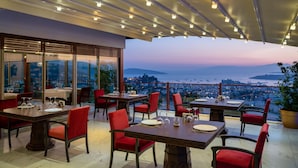 A restaurant with tables and chairs, a view of the city, and a balcony with a railing. - Hillstone Bodrum Hotel & Spa (Bodrum)