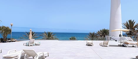 Relax on the beach with a scenic view of the ocean and a picturesque lighthouse.