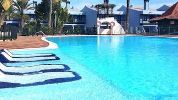 Una piscina al aire libre, una piscina climatizada