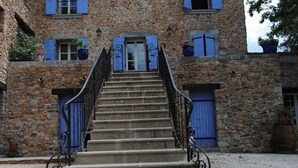 A stone building with a staircase leading to a door. - Detached 2-bedroom apartment in charming building, swimming pool and terrace (Signes)
