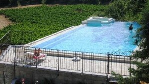 A rectangular swimming pool with a tiled deck and a metal railing. - Studio 5 in a charming building, swimming pool in the middle of vineyards (Signes)