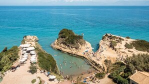 A coastal beach with a rocky outcrop, a sandy beach area, and a pool. - Akron Seascape Resort by Anayia All Inclusive Resorts (Corfu)