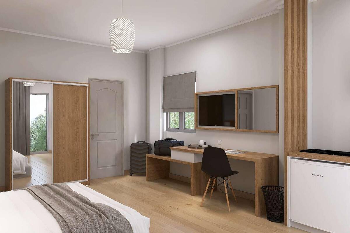 Een moderne slaapkamer met een bed, bureau en een klein keukenhoekje.