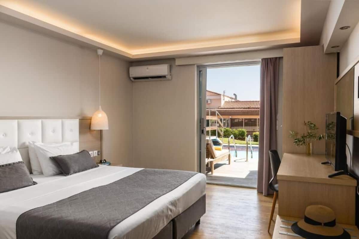 Een hotelkamer met een bed, bureau en uitzicht.